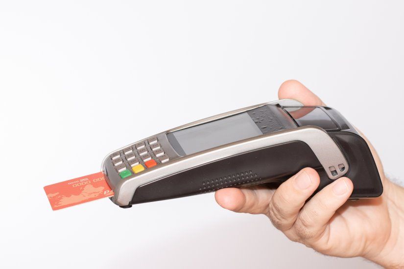 person-holding-payment-terminal-with-red-credit-card-swiped-through-machine_181624-20713.jpg